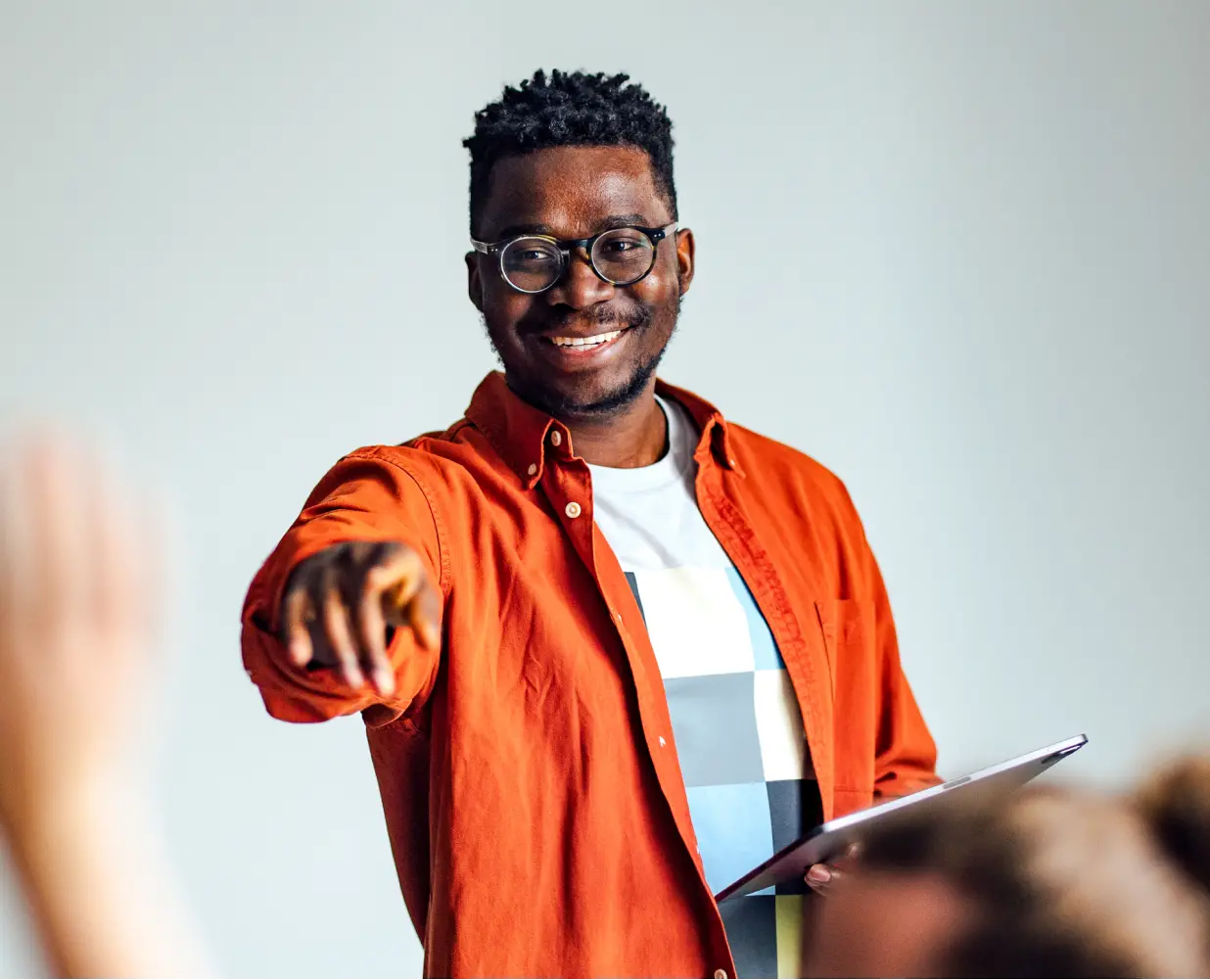 Teacher in a classroom holding a tablet.